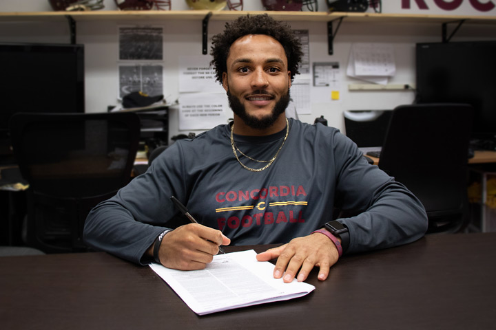 James Tyrrell signs his pro contact in the Concordia football office.